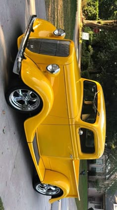 the yellow car is parked on the side of the road