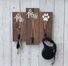 a couple of keys are hanging on a wooden sign