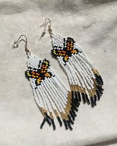 Elevate your style with these stunning beaded multi-color butterfly earrings, a whimsical accessory perfect for any occasion. Multicolor Butterfly Earrings For Pierced Ears, Handmade Multicolor Butterfly Earrings, White Beaded Butterfly Jewelry, White Beaded Butterfly-shaped Jewelry, White Beaded Butterfly Shaped Jewelry, Bohemian Butterfly Beaded Jewelry, Multicolor Butterfly Earrings, Bohemian Butterfly Shaped Beaded Jewelry, Multicolor Butterfly Charm Earrings