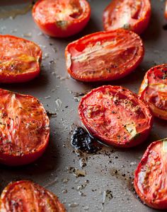 sliced tomatoes on a baking sheet ready to be cooked in the oven for roasting