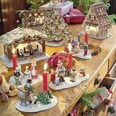 a table topped with lots of christmas decorations on top of a wooden table covered in candles