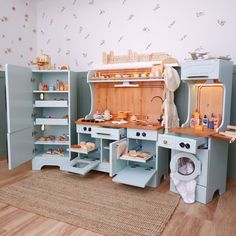 a child's play kitchen with blue cabinets and drawers