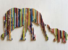 an animal made out of colored pencils on a white surface with the shape of a rhino