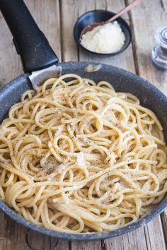 a pan filled with pasta on top of a wooden table