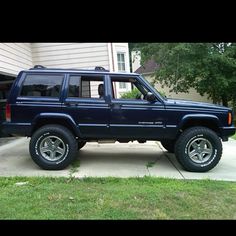 a blue jeep parked in front of a house