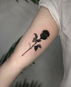 a black rose tattoo on the arm