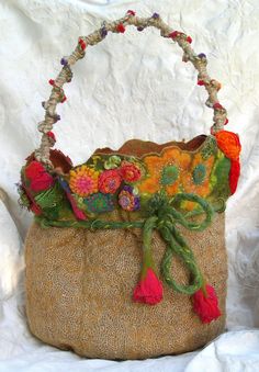 a handbag with colorful flowers and tassels on it's handle is sitting on a white background