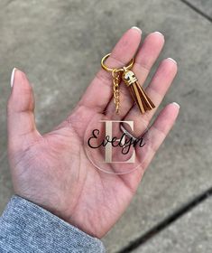 a hand holding a glass keychain with the word eleva written on it