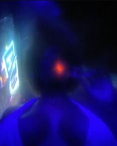 a blurry image of a man in front of a cell phone screen at night