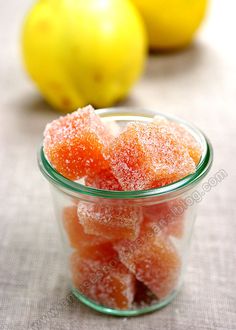 small glass jar filled with sugary candies next to lemons