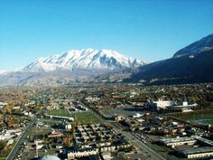 an aerial view of a city with snow covered mountains in the background and text that reads provo, utah