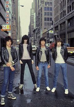 four people standing in the middle of a city street