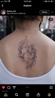 the back of a woman's neck with a fish tattoo on her left shoulder