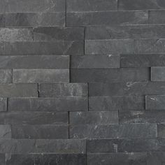 a black stone wall that has been made out of grey slate tiles with no mortars or mortars