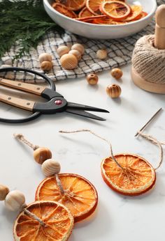 some orange slices are on a table with scissors and other things to make it look like they have been cut in half