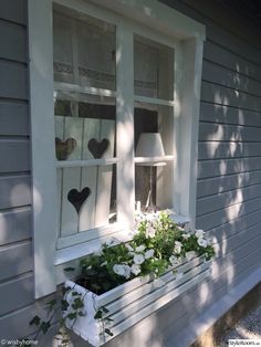 a window box with flowers in it on the side of a house