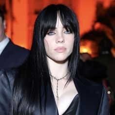 a woman with long black hair wearing a leather jacket