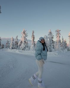 a woman is standing in the snow on skis