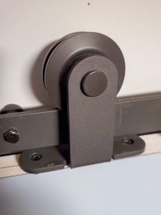 a close up view of a door handle on a sliding door with white walls in the background