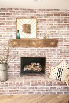 a brick fireplace in a living room next to a potted plant