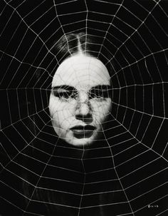 a woman's face is seen through a spider web