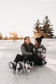 a man and woman sitting in the snow together