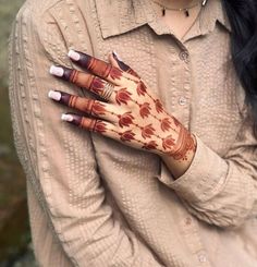 a woman is holding her hands painted with henna