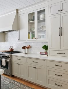 a large kitchen with white cabinets and stainless steel appliances, along with an island in the middle