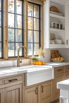 a kitchen with wooden cabinets and white counter tops next to a window filled with fruit