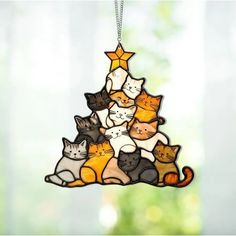 a stained glass christmas tree ornament with cats hanging from it's sides