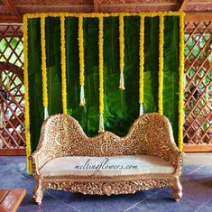 a decorated stage with yellow flowers and greenery on the wall in front of it