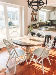 a kitchen table with four chairs around it