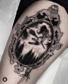 a woman's thigh with an image of a wolf in a frame on it