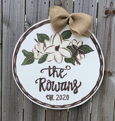 a sign that says the rowans next to a fence with a bow on it