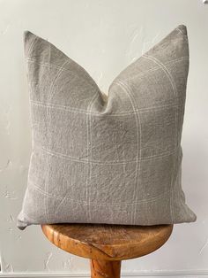 a gray pillow sitting on top of a wooden chair