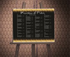 a black and gold wedding seating chart on a wooden easel in front of a brown wall