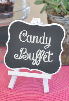 a candy buffet sign sitting next to a potted plant on top of a table