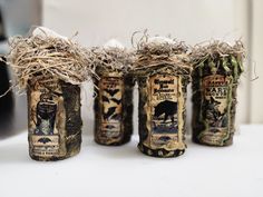 four jars with birds and bats on them sitting on a white counter top next to each other