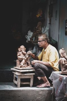 a man sitting in front of some statues