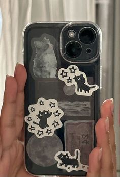 a person holding up a phone case with stickers on the front and back of it