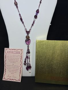 "Sunya Currie Purple And Clear Venetian Glass Beaded Necklace. The necklace has a gold tone metal tag that says Sunya Currie. There is 1 cupcake bead. It has no clasp it just slips over your head. The necklace measures: 36\" The tassel hangs an extra 6 \" longer It comes with the original gift box, velvet bag and provenance.. (Jewelry # 4276) USA Seller!! Estate sale find. We do not Clean or Polish our Estate Jewelry we will leave that to you. We also have Jewelry, Hallmark Ornaments, Dept 56, Vintage Glassware and many other items. We will combine shipping for multiple items if possible. Features: * no clasp Size: Womens 36\" Condition: Pre-Owned Like New" Adjustable Tassel Necklace With Dangling Beads For Gift, Adjustable Tassel Necklace With Dangling Beads As Gift, Adjustable Beaded Chain Tassel Necklace As Gift, Costume Jewelry Necklaces With Dangling Beads As Gift, Gold Beaded Tassel Necklace Gift, Beaded Dangle Long Necklace For Gift, Beaded Dangle Long Necklace As A Gift, Costume Jewelry Long Beaded Necklace As Gift, Beaded Tassel Necklace As A Gift