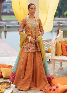 Orange Lehenga Skirt Dress for Pakistani Mehndi Wear is a masterpiece to wear this wedding. The beautiful details of tilla and resham give a traditional touch to this stunning Orange Lehenga Suit. An embroidered dupatta gives a perfect finishing look to this masterpiece. Orange Frock Design: An amalgamation of vibrant hues on a modern silhouette is all set to make a lasting impact. A gorgeous subtle orange silk base is emblazoned with the classic block print, with playful motifs is further uplif Farah Talib Aziz, Orange Lehenga, Pakistani Mehndi, Lehenga Suit, Lehenga Skirt, Pakistani Wedding Dresses, Boutique Dress Designs, Orange Shirt, Indian Designer Outfits