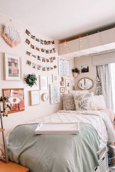 a bed room with a neatly made bed and lots of pictures on the wall above it