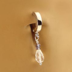 a close up of a wall with a ring on it and a crystal bead hanging from the side