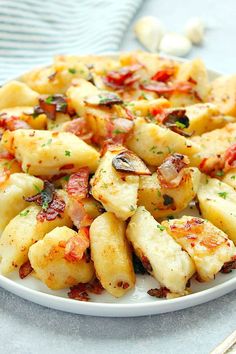 a white plate topped with ravioli and cheese covered in seasoning sprinkles