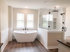 a large white bath tub sitting inside of a bathroom