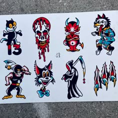 several stickers on the side of a white sheet with different designs and colors, including cats