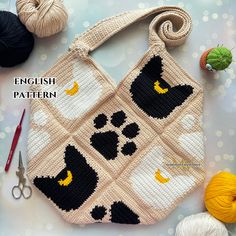 a crocheted bag with black and white cats on it next to knitting supplies