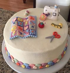 a cake decorated with sewing supplies on top of a table