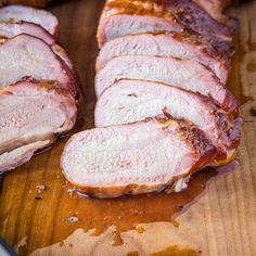 sliced pork sitting on top of a wooden cutting board